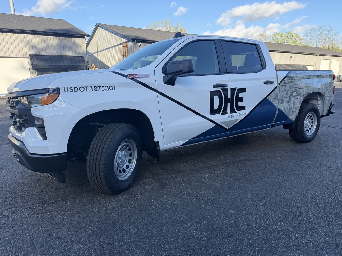 DHE fleet trucks with matching graphics installed by Good Graphics Co.